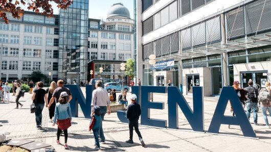 Besucherinnen und Besucher des Hochschulinfotages der Uni Jena laufen über den Campus Ernst-Abbe-Platz.