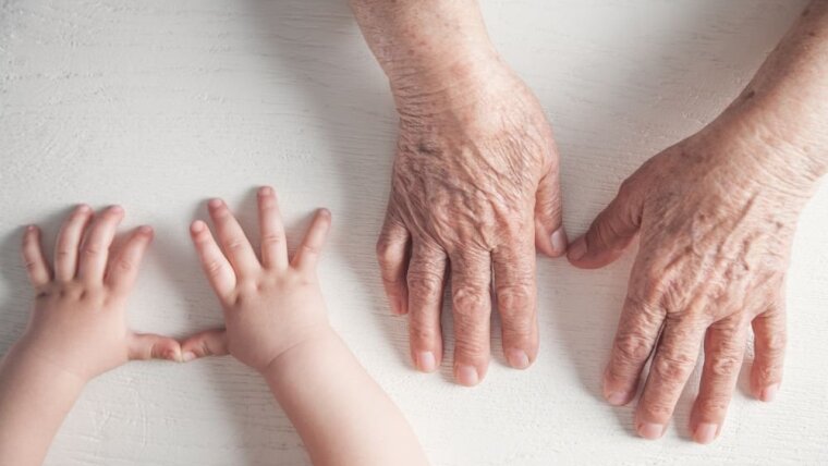 Hände eines Kindes und einer alten Dame